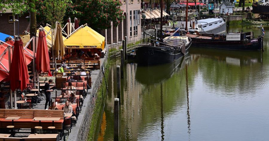 Nur wenige Gäste sitzen bei sonnigem Wetter in den Außenbereichen der Cafés und Restaurants am Historischen Hafen in Rotterdam (Archivbild).