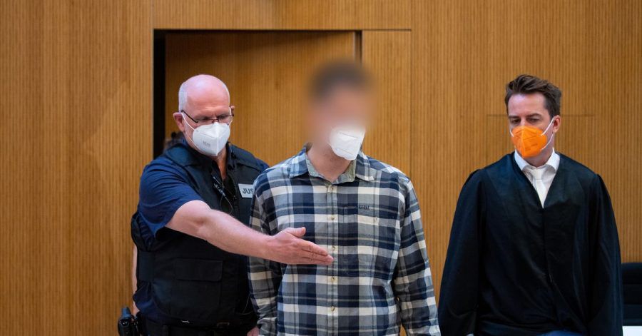 Einer von beiden wegen Mordes angeklagten Männer (m) wird in den Sitzungssaal geführt.