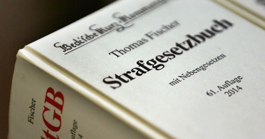 ILLUSTRATION - Das Strafgesetzbuch liegt in einem Gerichtssaal.