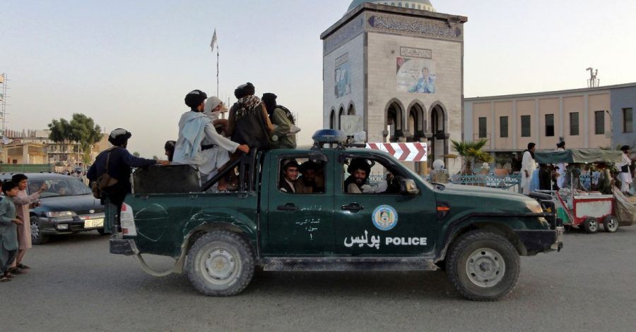 Taliban-Kämpfer patrouillieren in einem Polizeifahrzeug in Kandahar.