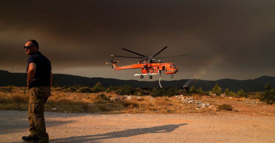 Ein Hubschrauber füllt einen Wassertank, um Vilia vor den Flammen zu schützen.
