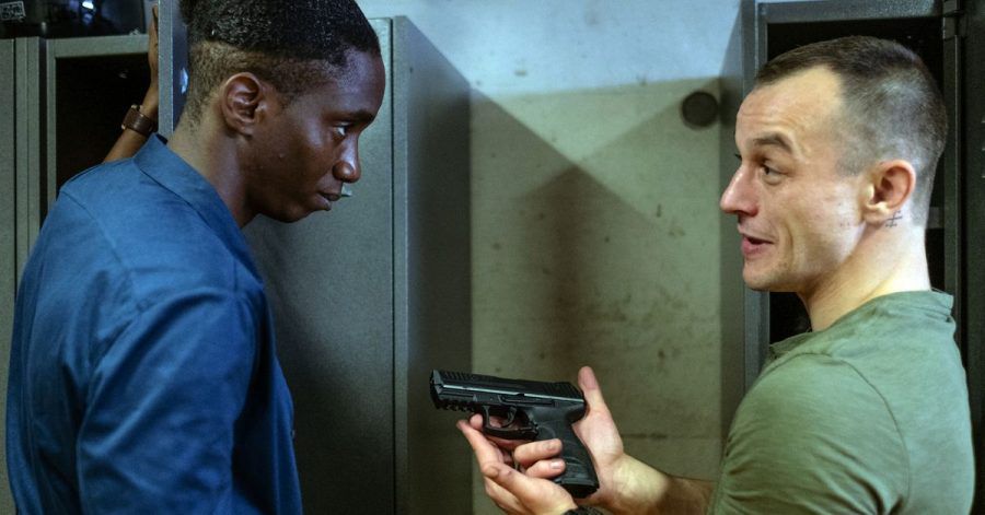 Mario (Paul Wollin, r) prahlt vor seinem Kollegen Man (Emmanuel Ajayi) mit seiner Pistole.