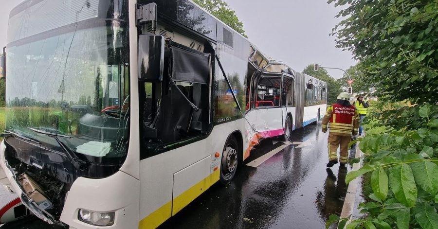 Der Zugführer der Feuerwehr Godshorn geht an einem stark beschädigten Linienbus an der Unfallstelle vorbei. Beim Zusammenprall eines Lkw mit einem Linienbus in Langenhagen ist ein Fahrgast im Bus tödlich verletzt worden.