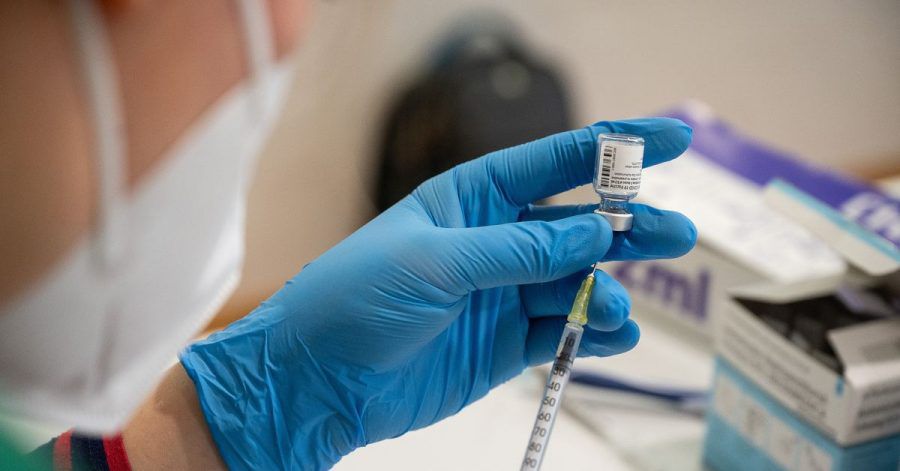 Die Mitarbeiterin eines mobilen Impfteams zieht den Impfstoff von Biontech/Pfizer in eine Spritze auf.