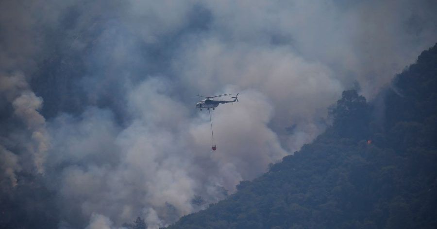 Ein Hubschrauber transportiert Löschwasser, um einen Waldbrand in der Türkei zu löschen.