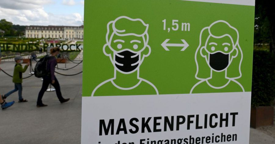 Ein Hinweisschild fordert zum Tragen von Schutzmasken gegen das Coronavirus auf.