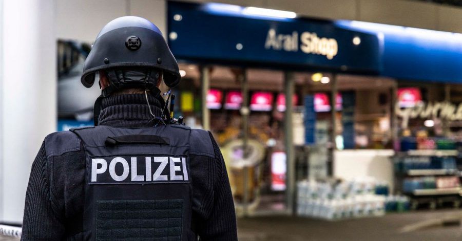 Ein Polizist steht vor der Tankstelle, an der ein Angestellter von einem Mann erschossen worden ist.