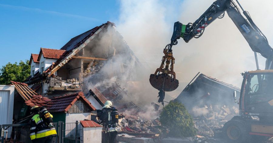 Ein Bagger räumt Teile des eingestürzten Hauses weg.