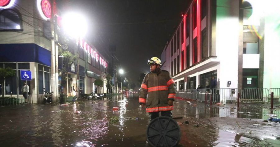 Ein Feuerwehrmann steht in einer überfluteten Straße in Ecatepec.