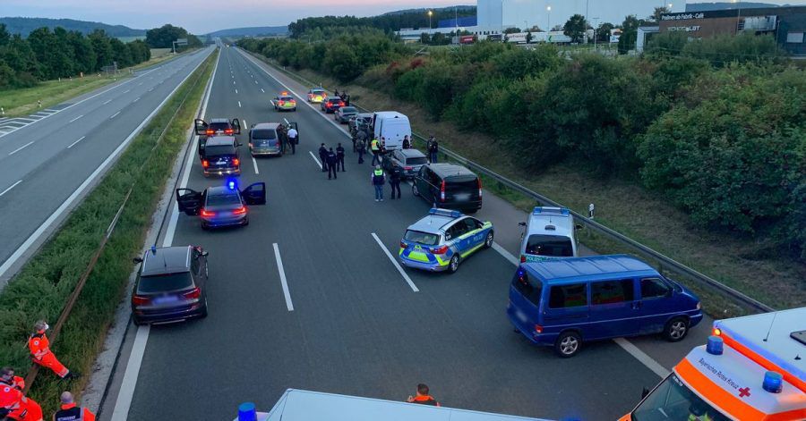 Polizisten und Helfer stehen mit ihren Fahrzeugen auf der Autobahn 9.