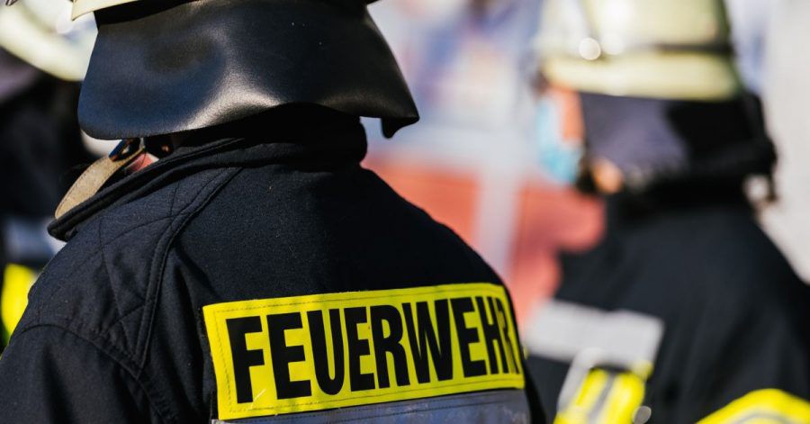 Einsatzkräfte der Feuerwehr stehen nebeneinander.