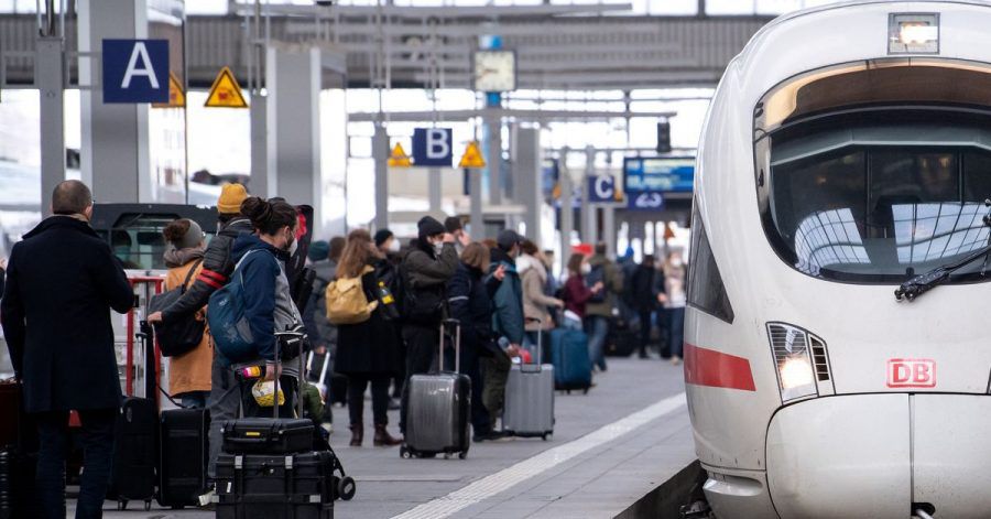 Reisende neben einem ICE am Münchener Hauptbahnhof.