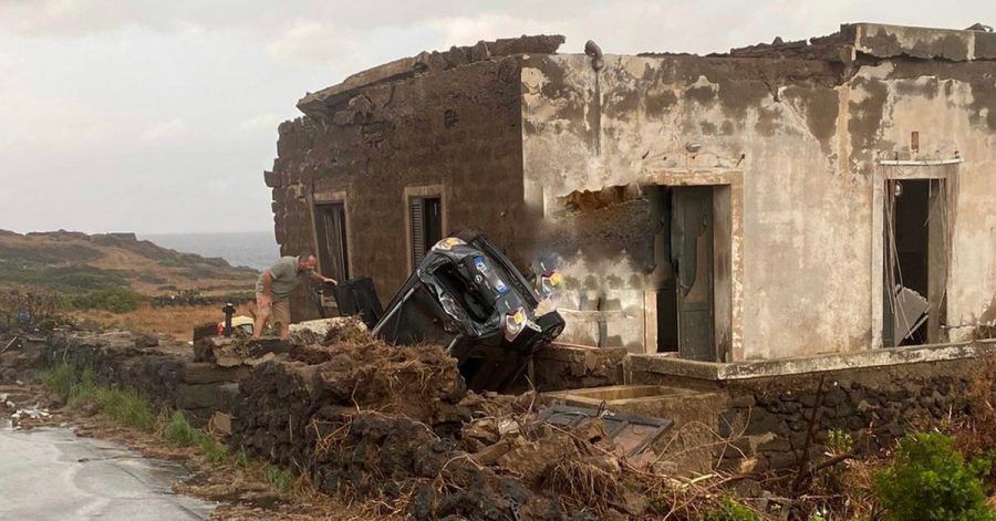 Ein zerstörtes Fahrzeug liegt abseits der Straße an einem Haus. Auf der italienischen Mittelmeerinsel Pantelleria sind zwei Menschen bei einem Unwetter ums Leben gekommen.