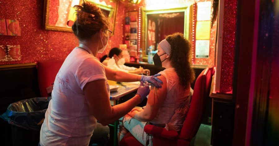 Eine junge Frau lässt sich in einer Bar nahe der Reeperbahn im Stadtteil St. Pauli gegen das Coronavirus impfen.