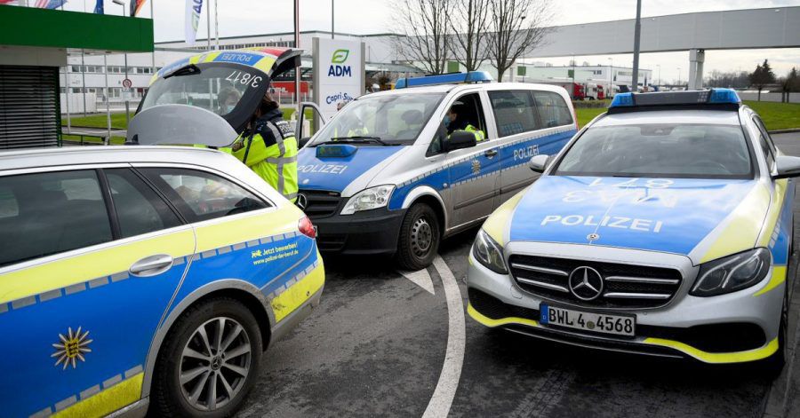 Fahrzeuge der Polizei stehen vor dem Werk eines Getränkeherstellers, wo eine Serie explosiver Postsendungen begannn. Jetzt wird wird einem 66-jährigen Elektriker der Prozess gemacht.