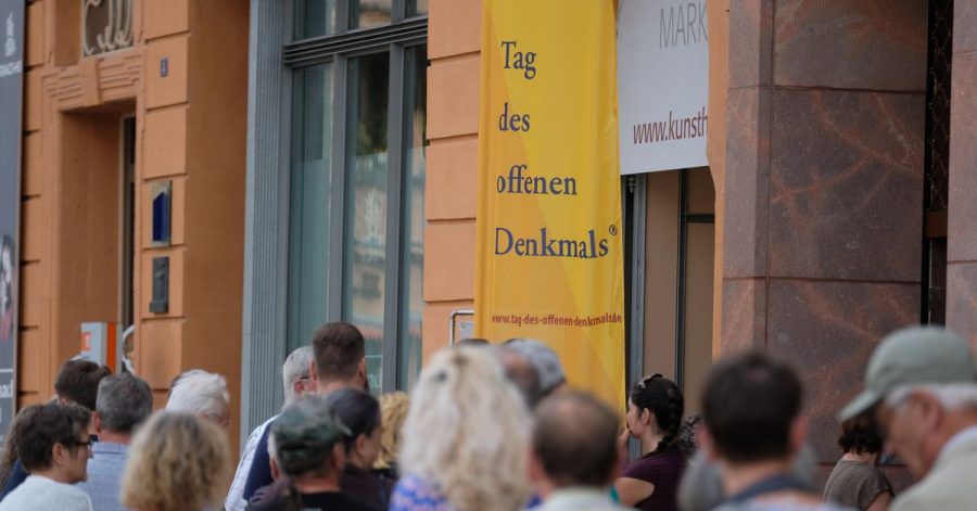 Besucher stehen vor einem historischen Gebäude in Wittenberg Schlange.