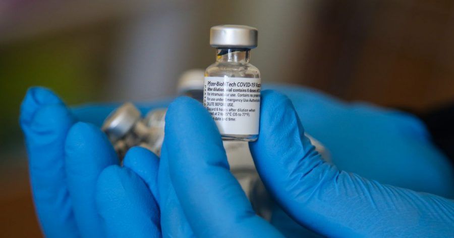 Ein Impfarzt hält einen Behälter mit dem Impfstoff gegen Covid-19 von Pfizer in einem Impfzentrum während der Impfung.