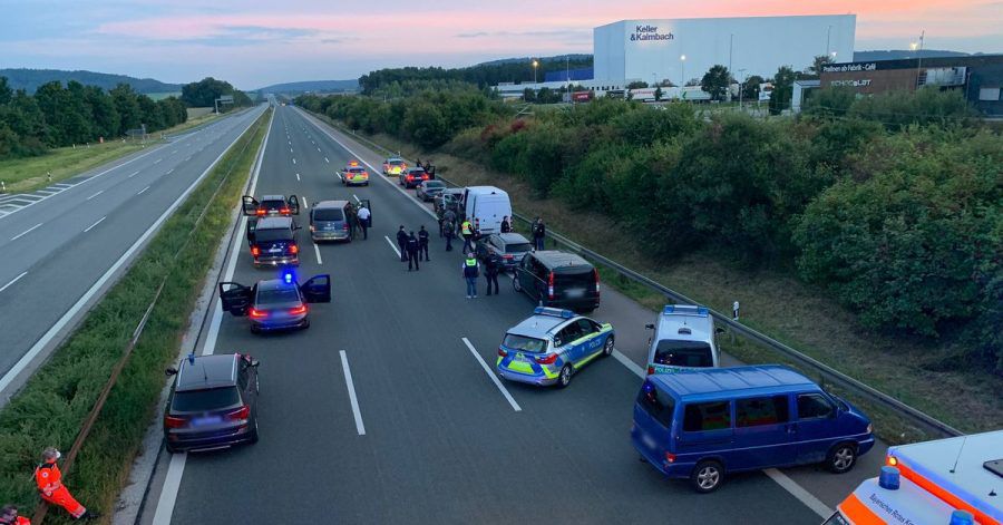 Polizisten und Helfer stehen mit ihren Fahrzeugen auf der Autobahn 9.