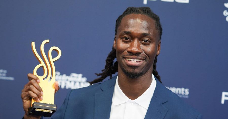 Der Schauspieler Eugene Boateng zeigt seinen Preis.