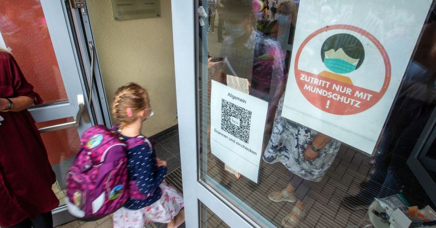 Ein Kind geht mit Maske in eine Schule. Das Robert Koch-Institut (RKI) registriert in einzelnen Regionen Deutschlands besonders viele Corona-Ansteckungen bei Kindern und Jugendlichen.