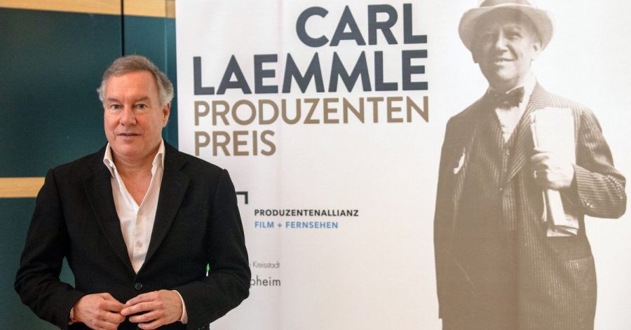 Nico Hofmann neben einem Porträt von Carl Laemmle.