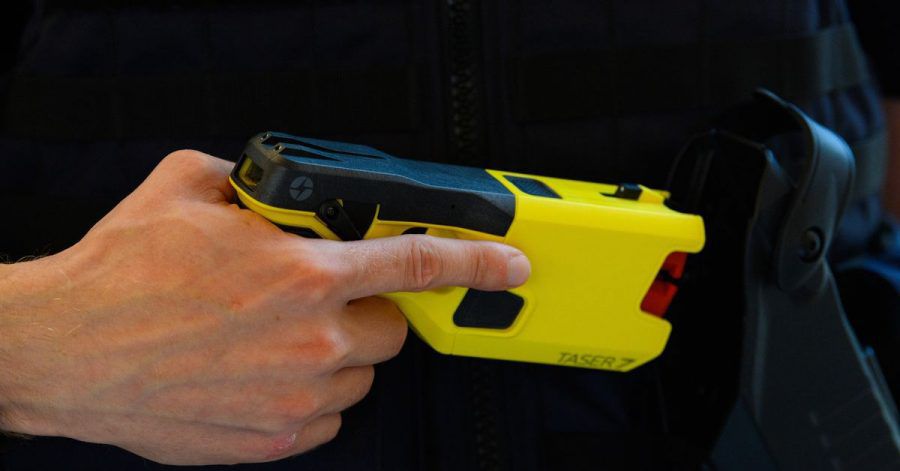 Ein Polizeibeamter präsentiert einen Taser.