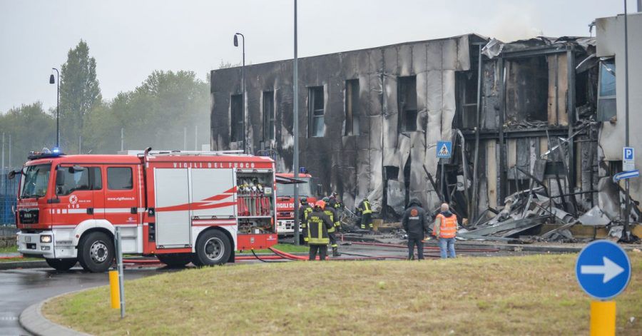 Feuerwehrleute stehen an der Unfallstelle, nachdem ein Leichtflugzeug kurz nach dem Start abgestützt und in ein leerstehendes Bürogebäude gekracht ist.