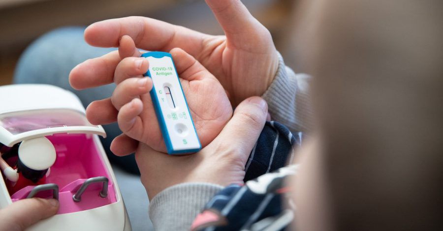 Ein Kita-Kind und seine Mutter warten daheim auf das Ergebnis eines Corona-Selbsttests.