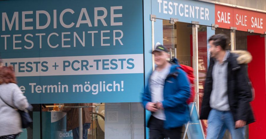 Passanten gehen an einem Corona-Testzentrum in der Münchner Innenstadt vorbei.