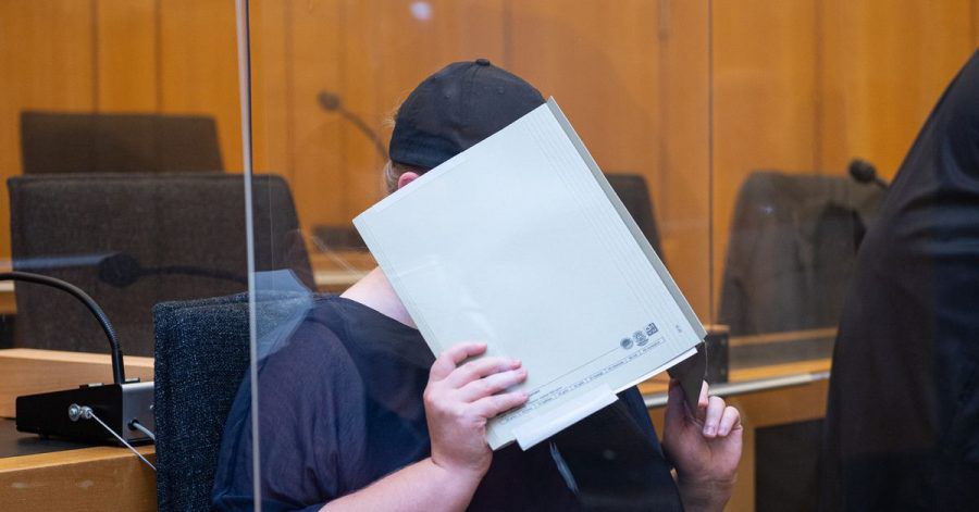 Zu Beginn des Prozesses im Missbrauchskomplex Münster sitzt die Mutter eines Opfers im Landgericht Münster und verdeckt ihr Gesicht mit einer Mappe. (Archivbild)