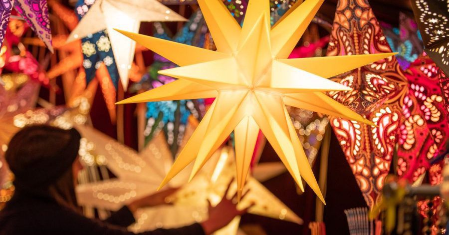 Bunte Weihnachtssterne werden an einem Stand auf dem Weihnachtsmarkt angeboten.