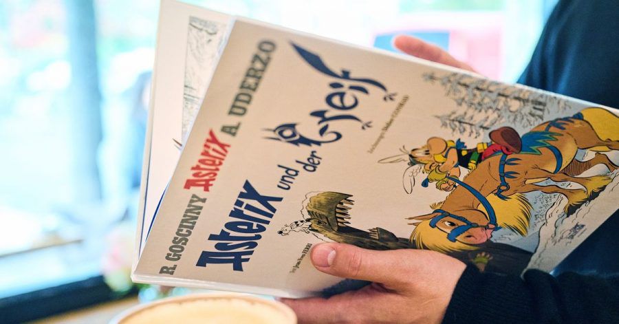 Ein Mann schaut in den neuen Asterix-Band "Asterix und der Greif".