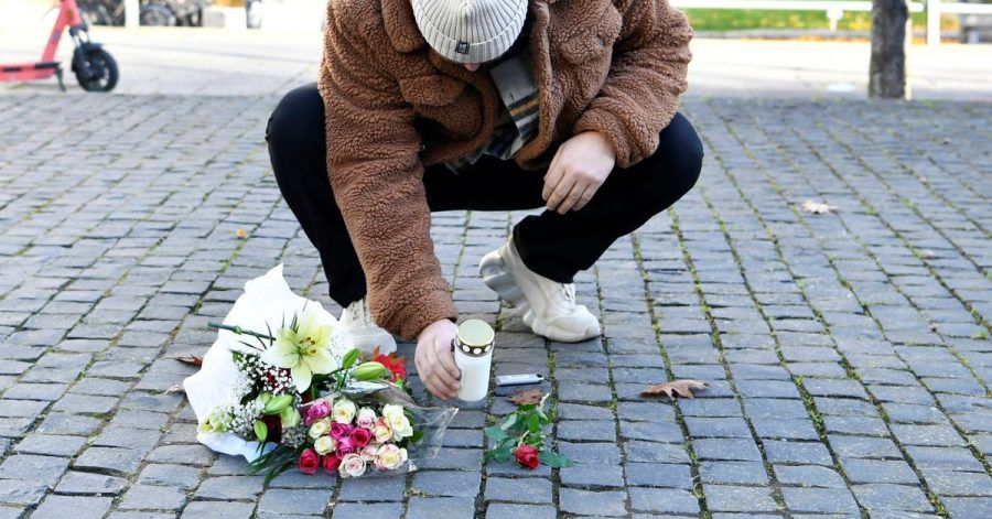 Ein Mann legt am Tatort Blumen und eine Kerze für den Musiker Einár nieder.