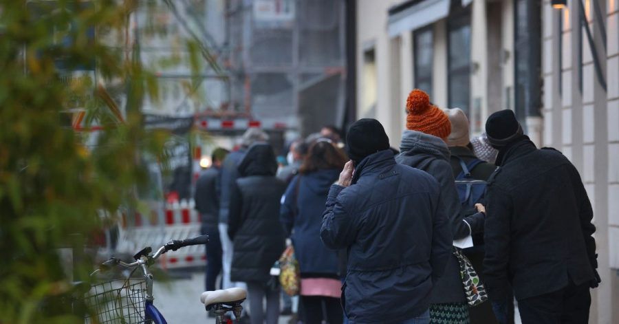 Menschen warten in einer langen Schlange vor einem Corona-Test- und Impfzentrum in Augsburg.