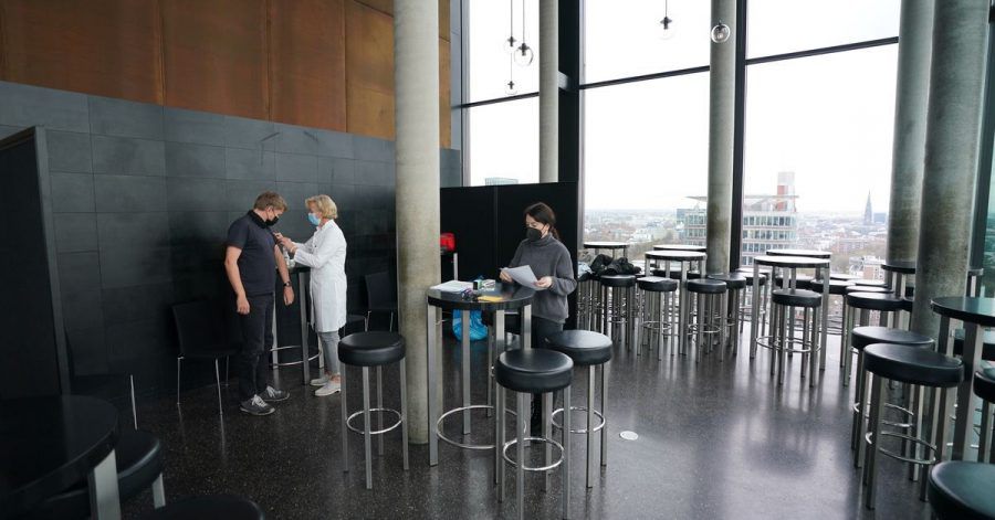 Ein Mann lässt sich in der Skyline Bar 20up im 20. Stock des Empire Riverside Hotels am Hamburger Hafen impfen.