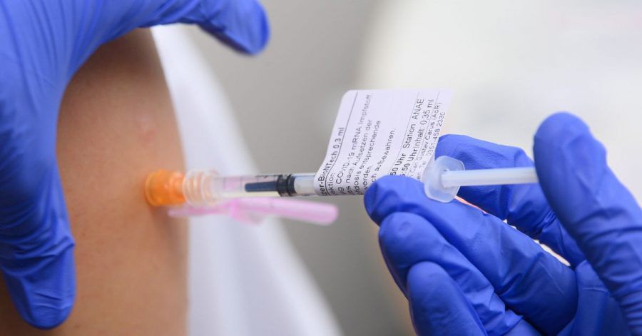 Eine Ärztin impft im Universitätsklinikum in Dresden einen Arztkollegen mit der dritten Impfung gegen das Coronavirus.