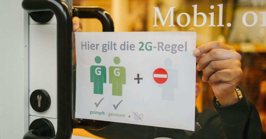 Ein Friseur in Hannover hängt verweist in seinem Schaufenster auf die 2G-Regel.