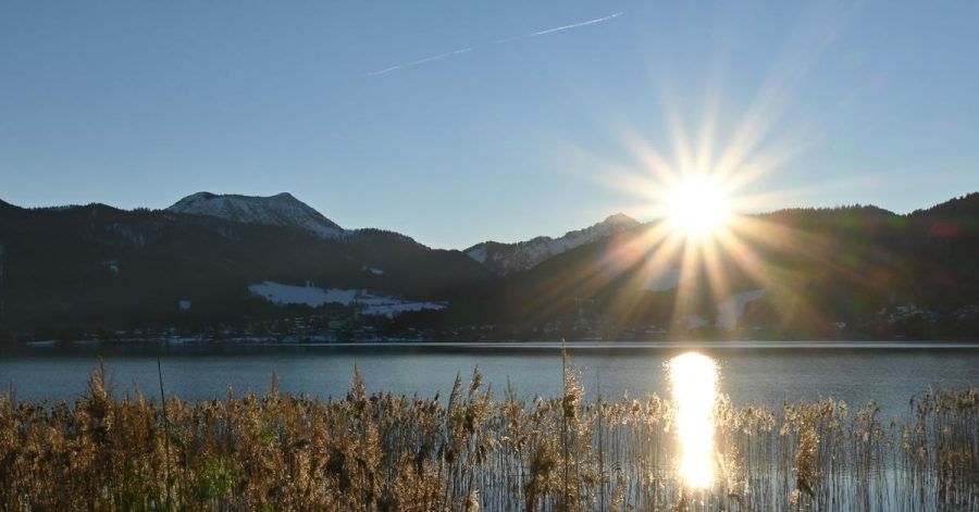 Sonne hinter den Bergen im Tegernseer Tal in Bayern.