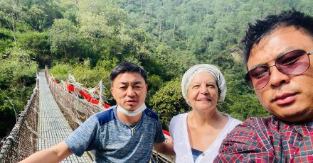 Fran Bak steht auf einer Hängebrücke mit ihrem Guide Gembo NB (l) und ihrem Fahrer Tashi Tshering. Sie ist seit der Pandemie die erste Touristin, die Urlaub im Königreich Bhutan machen darf.