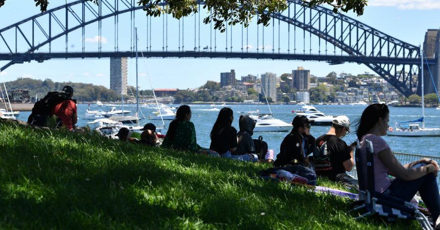 Vor den Silvesterfeierlichkeiten in Sydney versammelt sich eine kleine Menschenmenge an einem Aussichtspunkt mit Blick auf die Harbour Bridge.