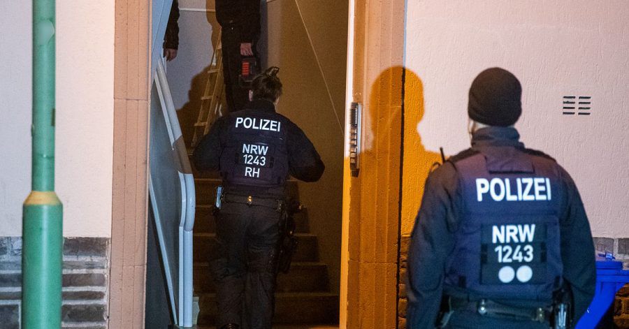 Einsatzkräfte der Polizei durchsuchen ein Mehrfamilienhaus in Essen.