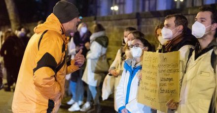 Ein Teilnehmer einer als «Spaziergang» deklarierten Demonstration von Impfgegnern und Kritikern der Corona-Maßnahmen steht am Universitätsklinikum Dresden vor zahlreichen Gegendemonstranten.