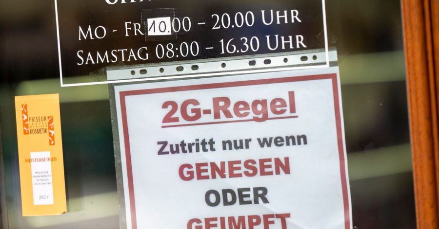 Ein Schild zur «2G-Regel» hängt an der Eingangstür eines Münchner Friseurladens.
