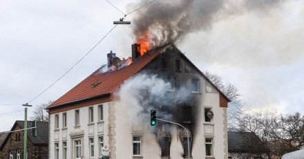 Einsatzkräfter der Feuerwehr sind bei einem Brand in einem Mehrfamilienhaus im Einsatz.