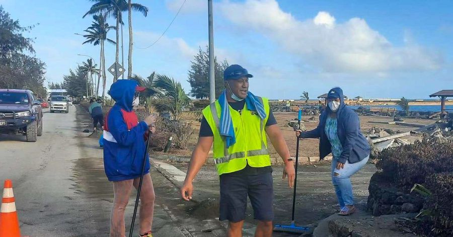 Anwohner fegen Asche von einer Straße nach dem Ausbruch eines unterseeischen Vulkans vor Tonga.