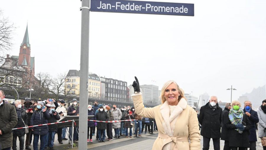Witwe Marion Fedder unter dem neuen Straßenschild der Jan-Fedder-Promenade. (jom/spot)