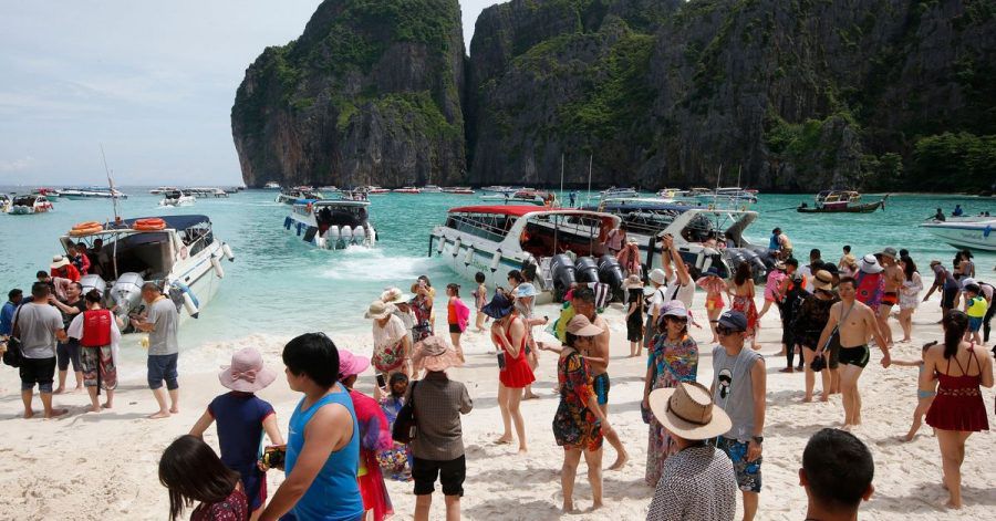 Touristen besuchen den Strand Maya Bay.