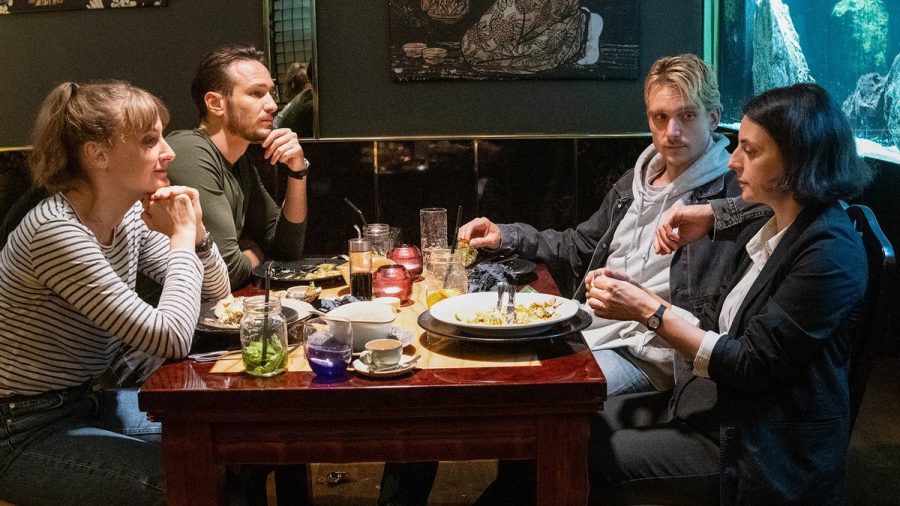 "Tatort: Das Herz der Schlange": Die Hauptkommissarinnen und Hauptkommissare feiern bei einem Abendessen den Abschluss eines Falls: Pia Heinrich (Ines Marie Westernströer, l.), Leo Hölzer (Vladimir Burlakov), Adam Schürk ( Daniel Sträßer, r.), Esther Baumann (Brigitte Urhausen). (ili/spot)