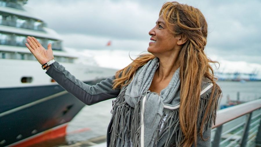 Nadja Abd el Farrag am Hamburger Hafen zeigt auf ein Schiff