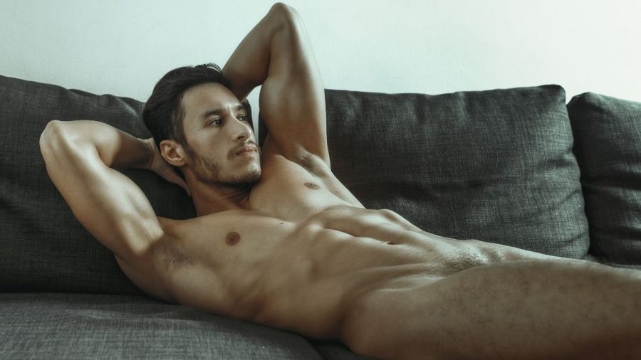 Ein männliches Model nackt im Bett
